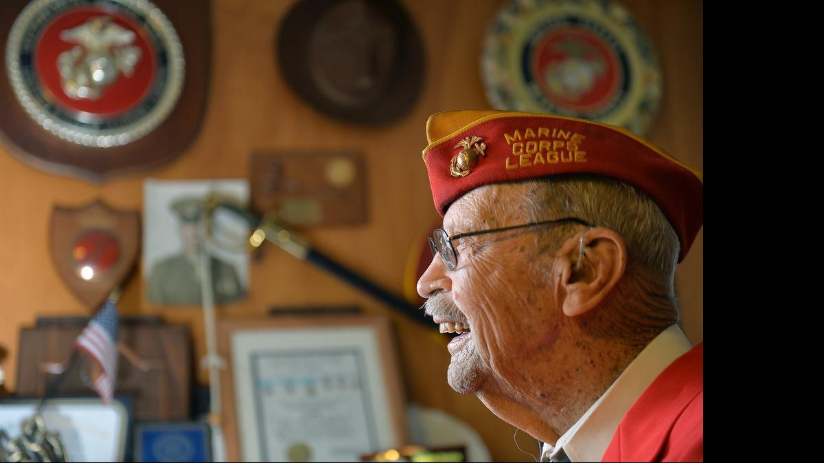 
World War II veteran Vincent Shuttera, 97, shows off a wall filled with photos and mementoes of his wartime experience in his home in Fresno, California on May 23, 2015. Shuttera served in the U.S. Marines for four years.
