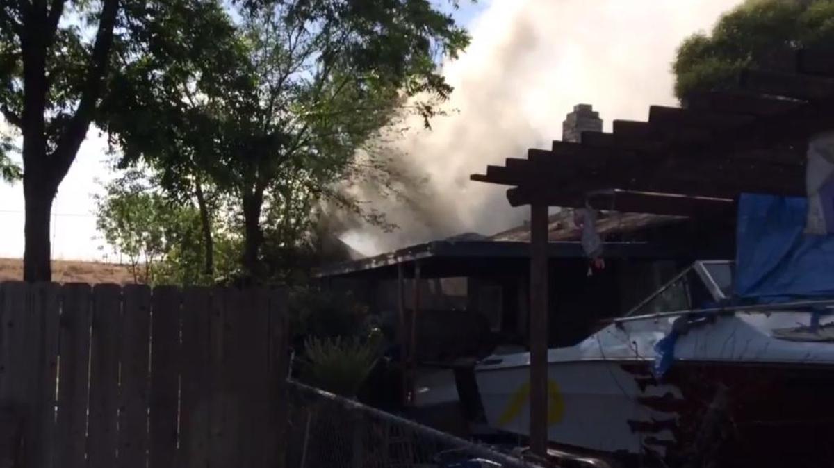 Smoke pours out of a southeast Fresno home during a two-alarm fire on Monday, May 2, 2016.