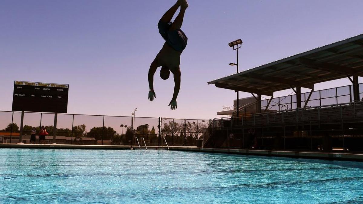 James Edwards jumps into the new pool at Edison High School’s Aquatics Complex on a warm June 20, 2016 in Fresno, Calif. The city has a new agreement with Fresno Unified to open school pools to the public this summer.