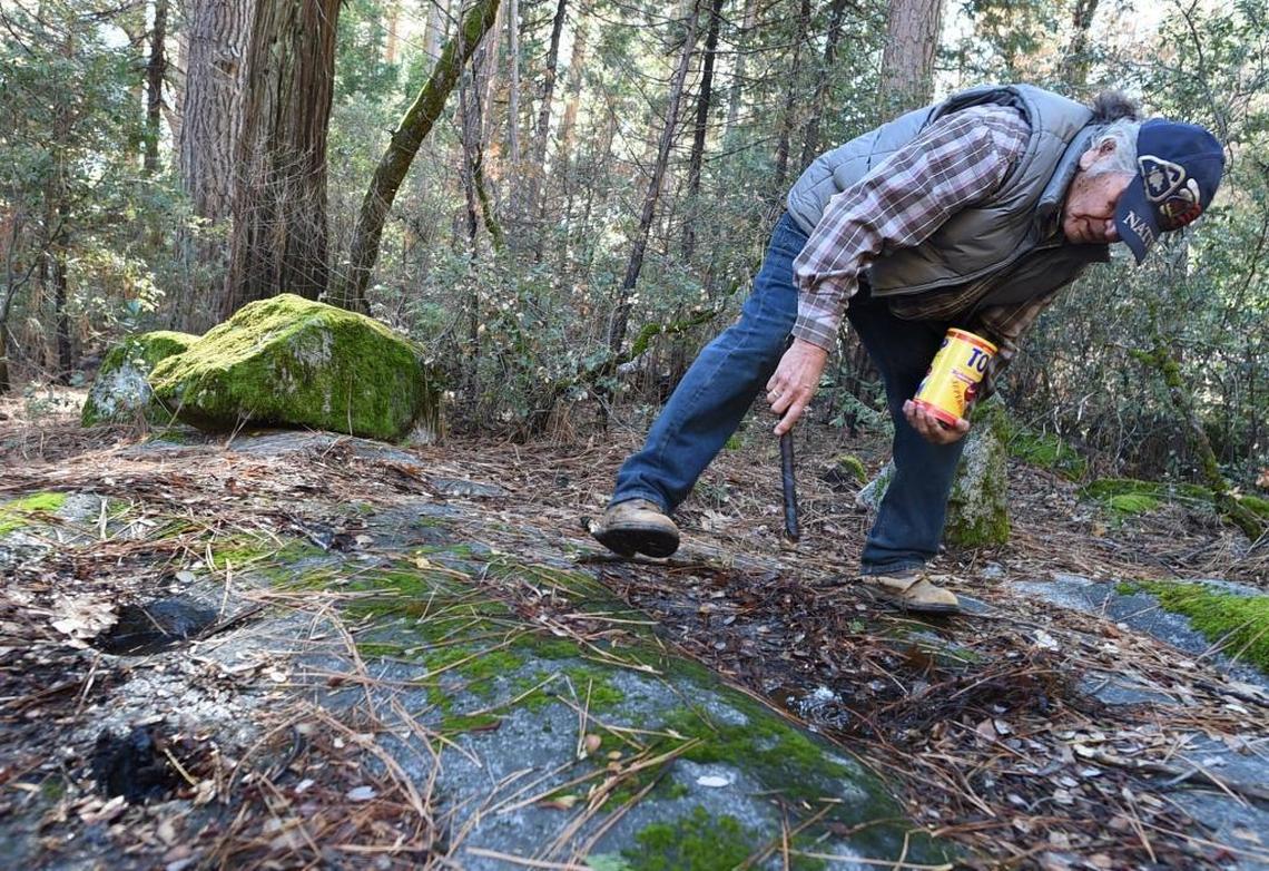 Tribal elder Bill Tucker points out ancient grinding holes at the site of a Native American village being reconstructed in Yosemite Valley, Nov. 30, 2017.