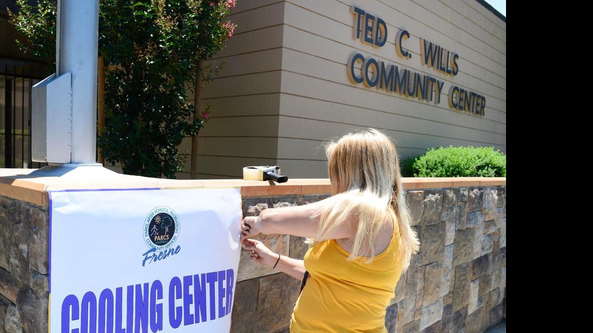 
Wendi Danyluk of the city of Fresno recreation department puts up a cooling center sign on the in front of the Ted C. Wills Center in Fresno Monday, June 8, 2015. More hot temperatures are expected, so the city’s cooling centers are about to reopen.
