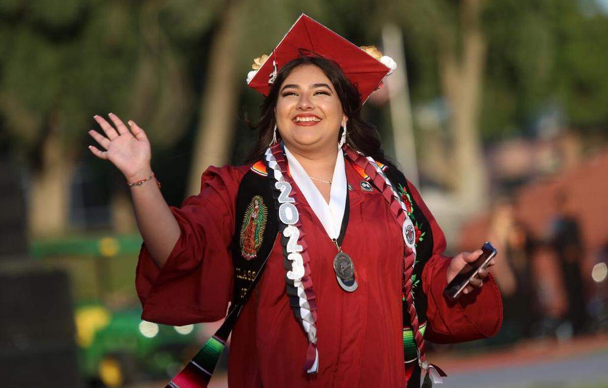A graduate walks in at the start of the first graduation ceremony for Matilda Torres High School at Madera Memorial Stadium on June 10, 2023.