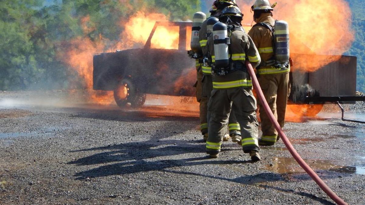 Firefighters work to extinguish a simulated car fire as part of their training.