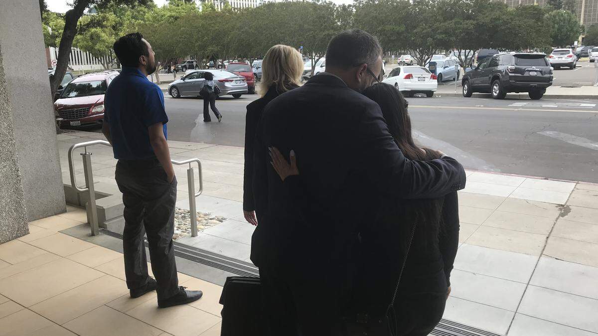 Fresno attorney David Moeck consoles his crying client, Grecia Sanchez, on the steps of the downtown courthouse after a Superior Court jury on Friday, May 25, 2018, ruled that two doctors did not cause the death of Sanchez's newborn son Jayden in December 2012. At left,  Francisco Prudente, the father of Jayden, stares into the distance.
