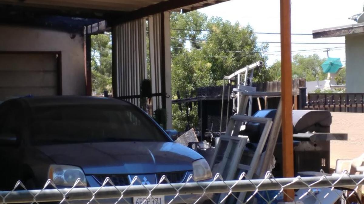 A fence was charred by a fire that threatened two homes in southwest Fresno on July Fourth. A Fresno police officer was the first to see smoke and flames and got the residents out.