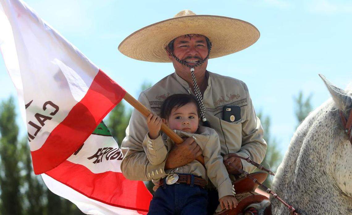 Raúl González holds his grandson, Nicolás Espinoza González during the 45th annual Joaquín Murrieta Horse Pilgrimage at Three Rocks on July 30, 2023.