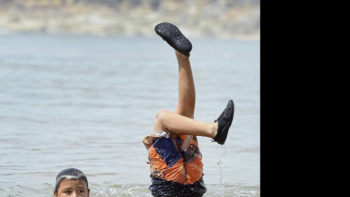 
Angel Torres, left, 8, and his brother Christopher Torres, 10, both of Kerman play in the water while cooling off with their family at Millerton Lake Monday.
