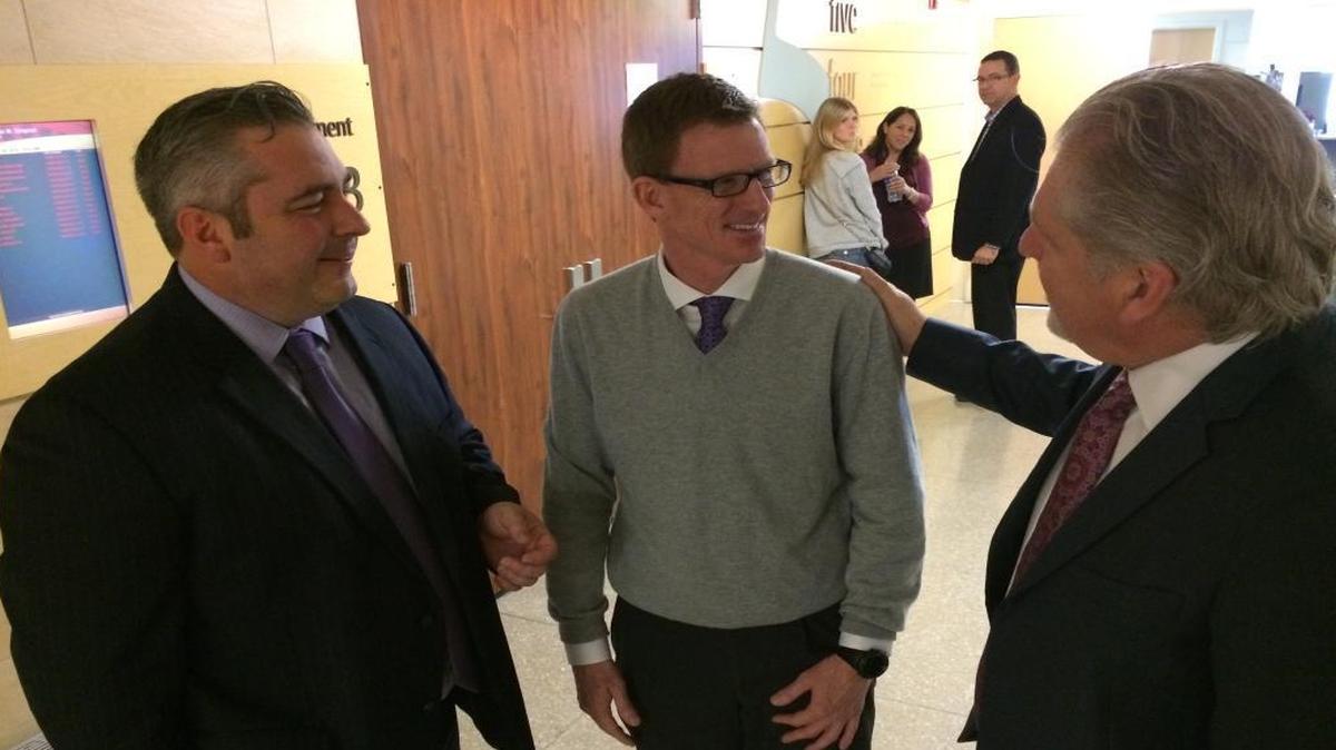Dr. Michael J. Moffett, center, chats with his lawyers, Travis Stokes, left, and Charles Doerksen, right, after testifying on Jan. 28.