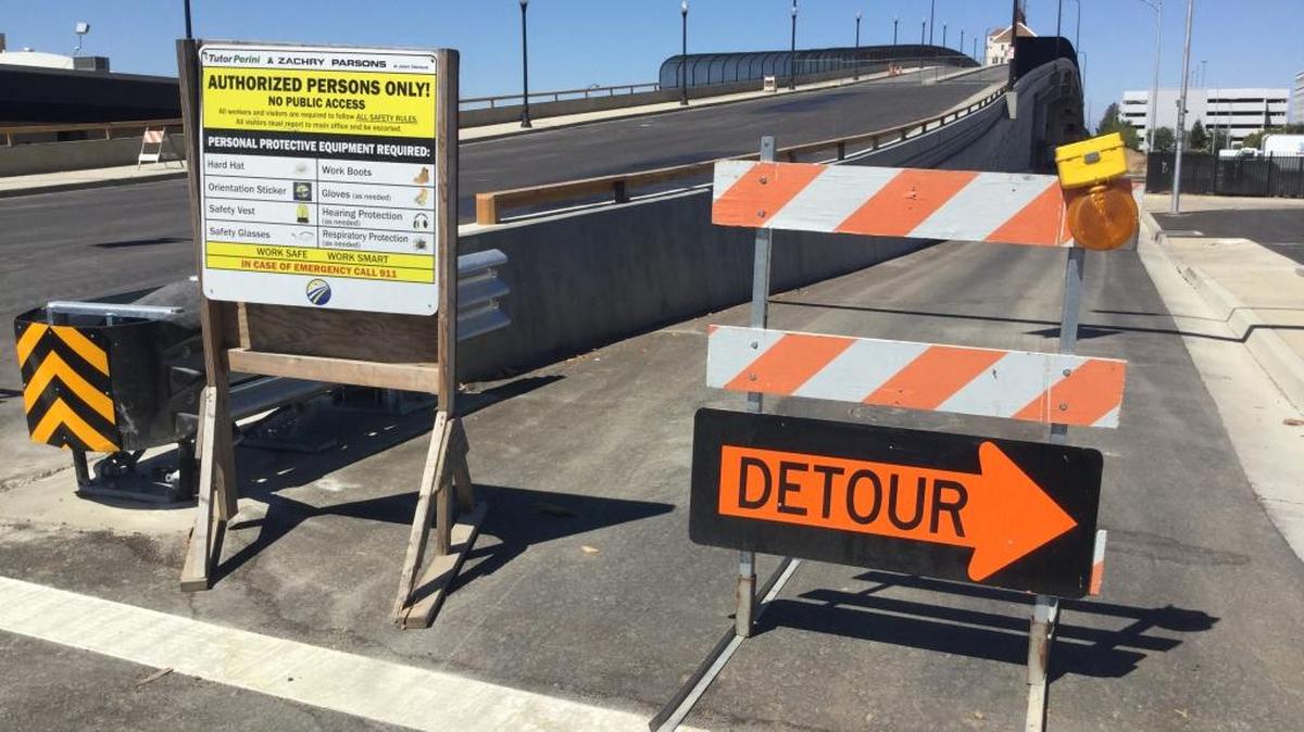 Signs and barricades guard the western slope of a new Tuolumne Street bridge over future high-speed rail tracks in downtown Fresno. The old one-way eastbound bridge was closed in January 2016 and demolished. The new bridge was originally anticipated to be open to two-way traffic by the end of 2016, but a wetter-than-normal winter delayed completion of the work. The new target for opening is mid-July.