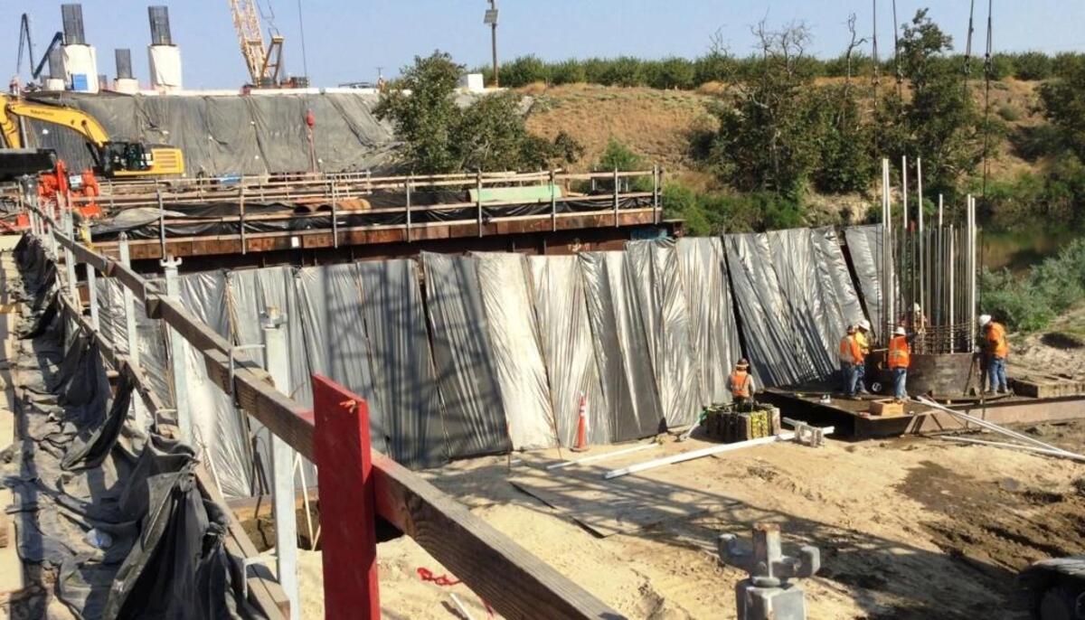 Construction crews work on building a new high-speed rail bridge over the San Joaquin River at the north end of Fresno on Aug. 17, 2017.