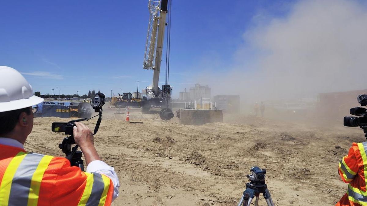 
Dust flies as media record High Speed Rail Authority officials and crews conduct a load test on a piling near Cedar and North avenues south of Fresno Thursday afternoon, June 18, 2015. The test was the fourth and final for the day on the 80-foot-deep piling where a bridge will eventually cross over Highway 99.
