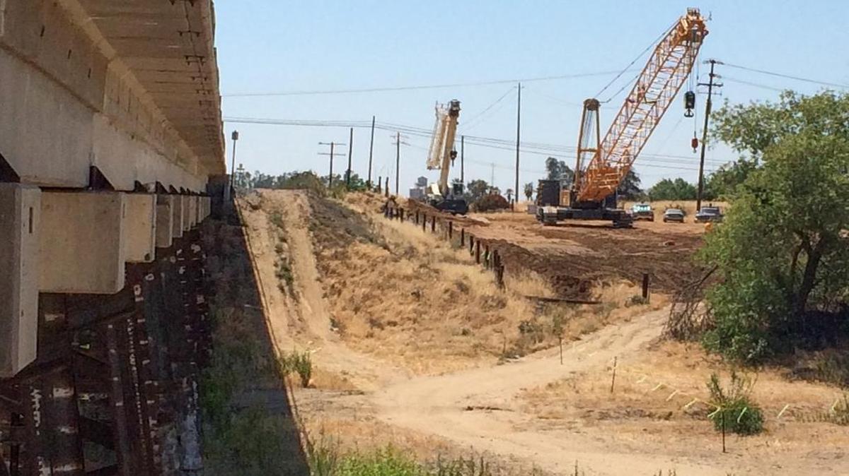 
Heavy equipment and crews prepare to begin building a viaduct over the Fresno River and Highway 145, near the BNSF Railway tracks in Madera — the first major construction in the San Joaquin Valley for California’s high-speed rail project. It’s been more than two years since the California High-Speed Rail Authority awarded the $1 billion construction contract for a 29-mile section of the route in Fresno and Madera counties, but significant delays in acquiring property for right of way stalled the start of construction.
