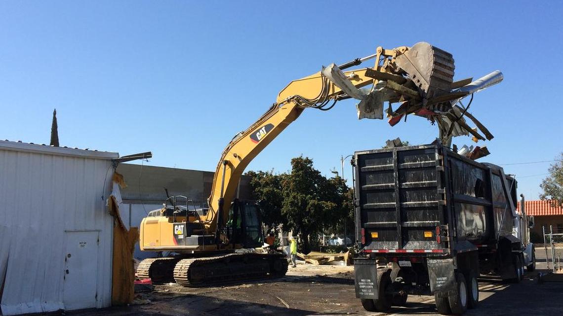 
An excavator dumps a load of what used to be part of the Paper Plus building into a truck to be hauled away. The building on G Street between Fresno and Merced streets was demolished Monday, part of path-clearing for California’s high-speed rail project.
