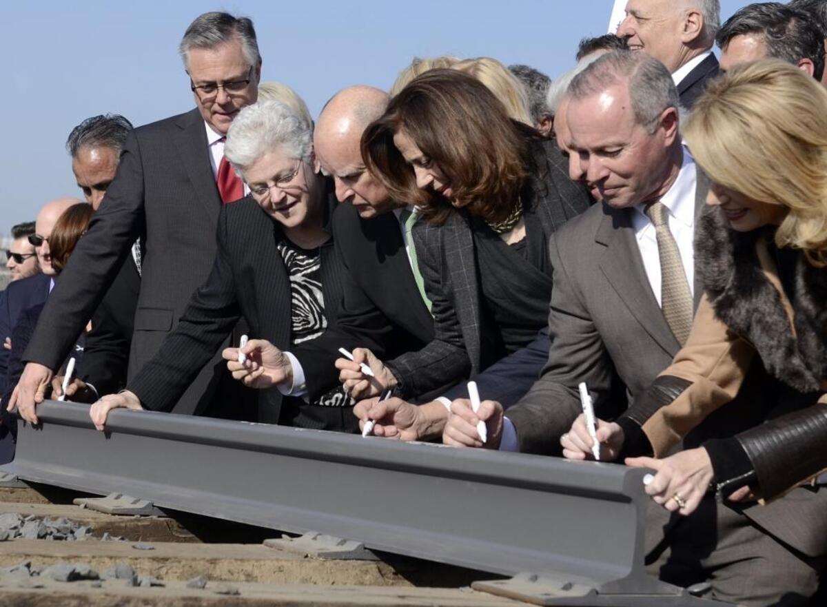 Gov. Jerry Brown, center, ceremoniously signs a section of rail, flanked by his wife, Anne Gust Brown, center right, and Gina McCarthy, administrator for the Environmental Protection Agency, center left, and other dignitaries sign during a groundbreaking in Fresno in January 2015. Others from left, then Supervisor Henry Perea (partially seen), Joseph Szabo, then-administrator of the Federal Railroad Administration, McCarthy, Gov. Brown, Anne Gust Brown, Robbie Hunter, secretary-treasurer of the State Building and Construction Trades Council of California and then-Mayor Ashley Swearengin.