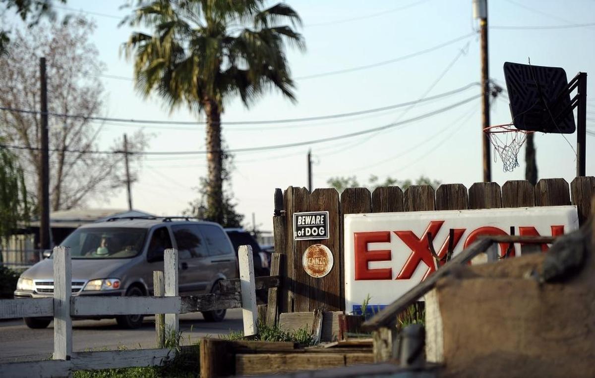 A van drives past an Exxon sign leaning along a fence at the former Strong’s Market Tuesday, March 14, 2017 at Matheny Tract, just south of Tulare, Calif.
