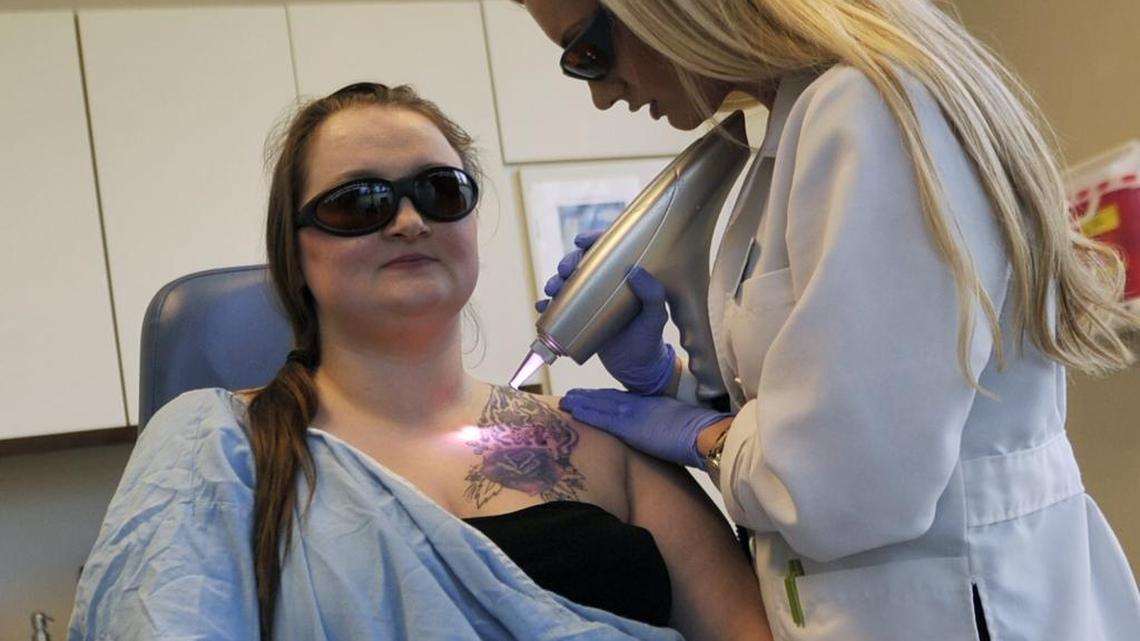 Arien Pauls, left, who had been branded with a tattoo by a human trafficking pimp, has her tattoo removed with laser treatment by Cassandra Biller, right, at Beautologie Cosmetic Surgery and Medspa in 2016 in Fresno.