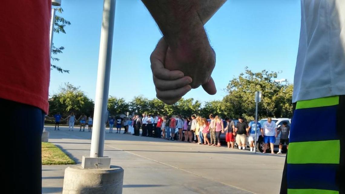 People take part in a prayer vigil Sunday evening at Buchanan High School for Toamalama Scanlan, one of two Fresno County sheriff’s correctional officers critically wounded in a shooting in the county jail lobby the day before.