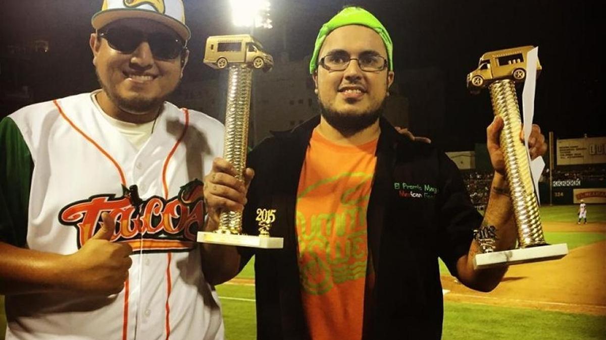 Adrian Loza, right, receives the Taco Truck Throwdown trophies after his family business wins the annual Fresno Grizzlies event last August. Loza died Jan. 23 after he was struck by a train.