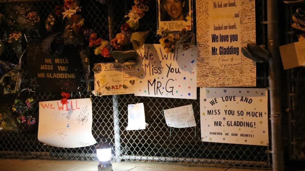 Messages, flowers and running shoes hang on a fence at Fort Washington Elementary School where Gavin Gladding was an administrator. The father of two was killed by a hit-and-run driver on Friant Road on Sept. 16.