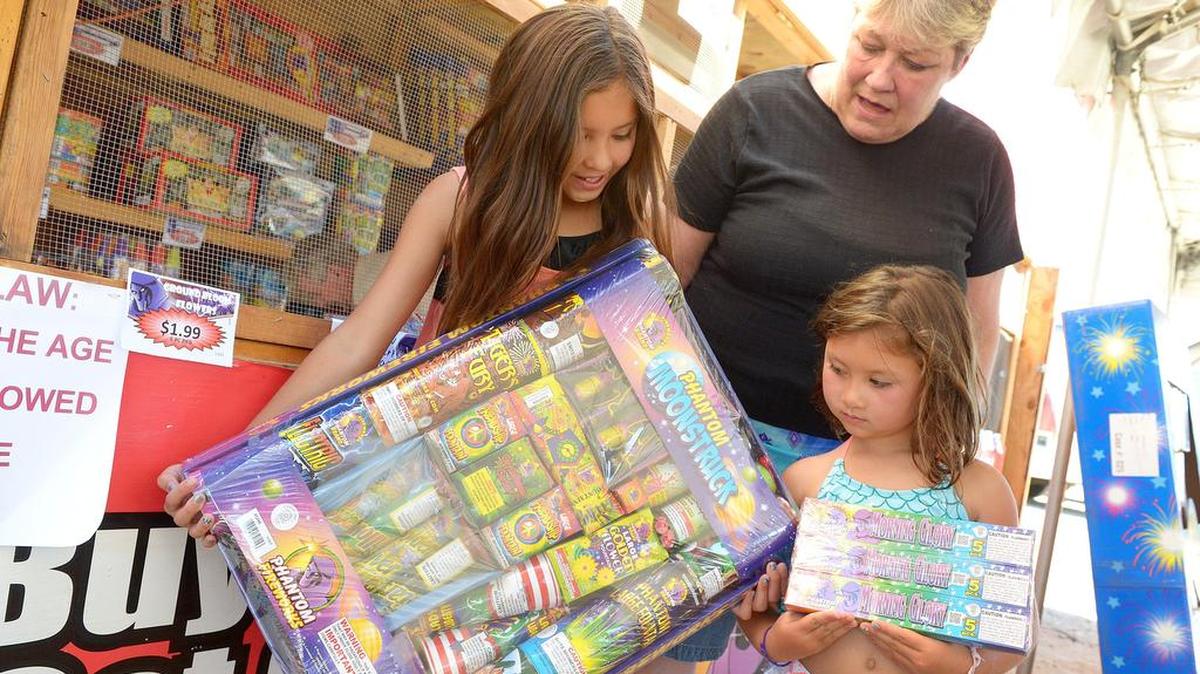 Aubrey Woo, left, 5, and her sister Tegan, 5, of Fresno, look over the fireworks packages they bought with their grandmother Molly Rasp at the VFW Post 3225 fireworks stand in Clovis on Sunday, July 2, 2017. Vendors are anticipating their big selling days to be Monday and Tuesday.
