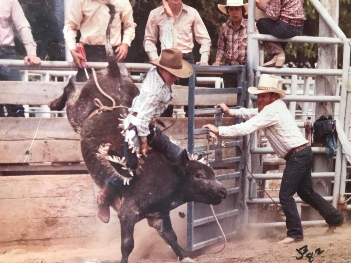 Kevin Blake Willard rides a bull at a rodeo as a young man.