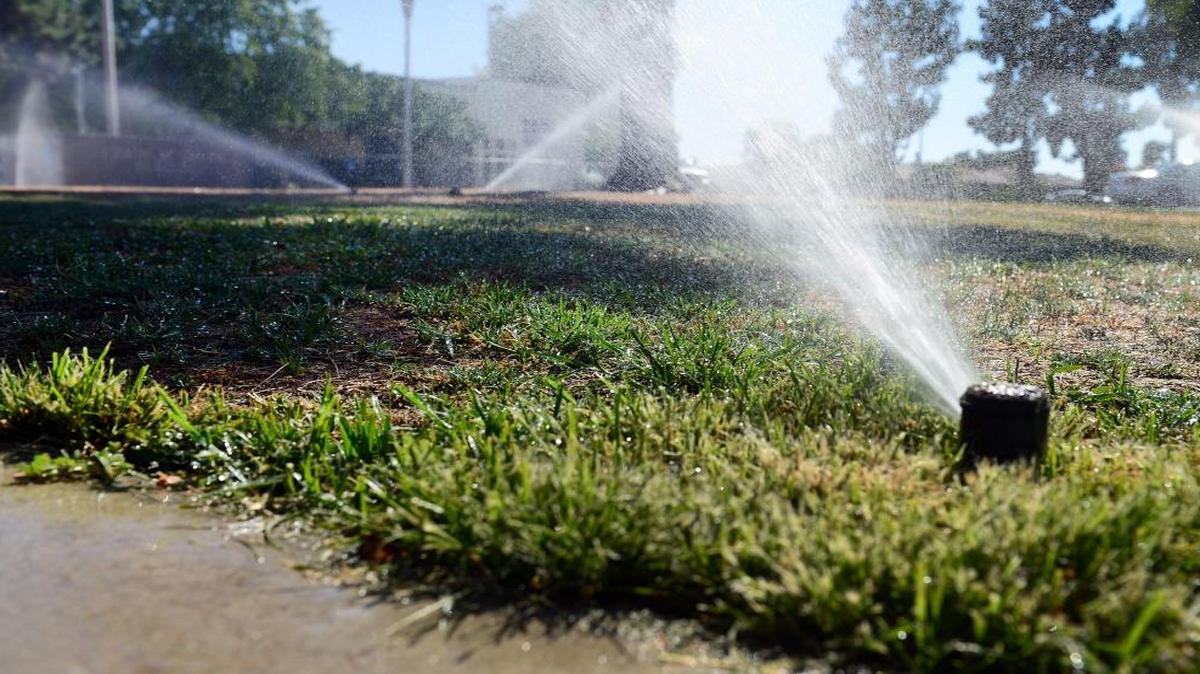 Sprinklers run on a grassy area in front of Fresno’s Eaton Elementary School in this 2014 photo.