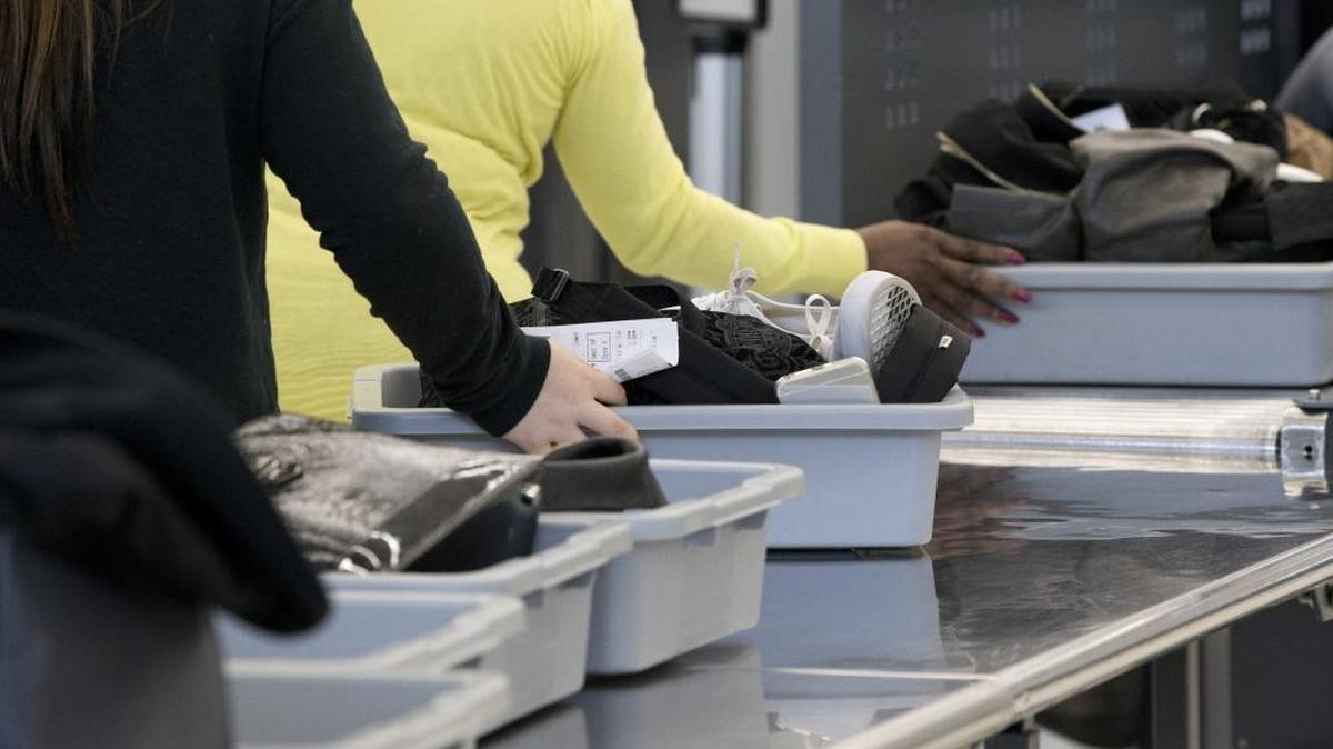Passengers load their items into bins to be scanned as they pass through security at the Fort Lauderdale-Hollywood International Airport, Friday, Dec. 18, 2015, in Fort Lauderdale, Fla.