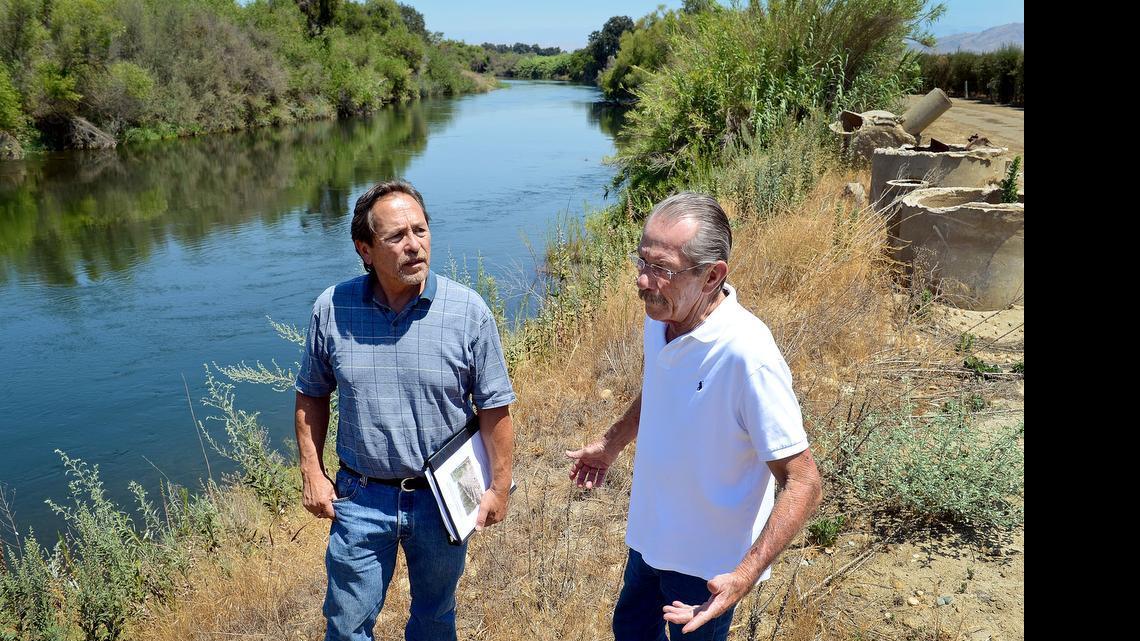 
Resource management mitigator John Buada, left, and Herb Lang of the Running Luck Ranch near Sanger stand on the bank of the Kings River on the ranch property last July. Lang is hoping to build a gravel mine plant on the property.
