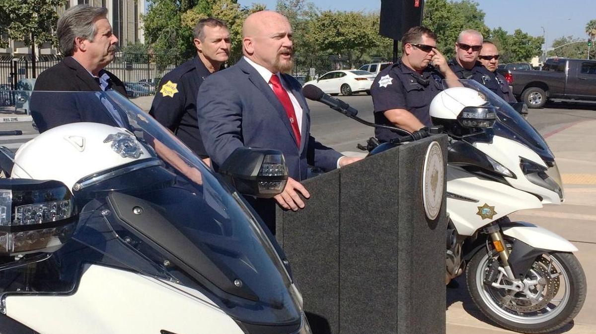 Fresno City Manager Bruce Rudd, far left, and Fresno Police Capt. Andy Hall, second from left, and several Fresno Police motorcycle officers listen outside Fresno City Hall as City Councilman Steve Brandau discusses the city’s two-week litter-enforcement effort.