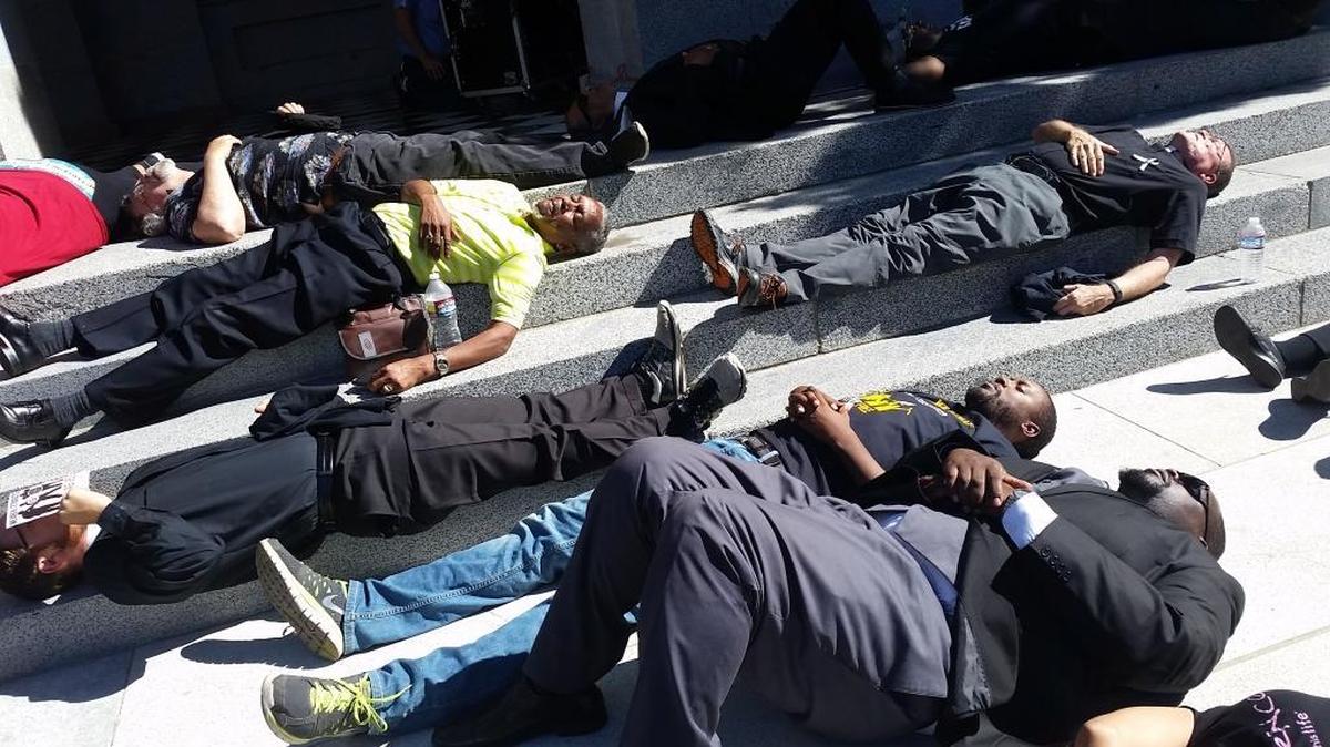 
Revs. D.J. Criner, center, and Bryson White, both of Saint Rest Baptist Church in southwest Fresno, participate in a “die-in” protest Wednesday in Sacramento in support of Assembly Bill 953, which seeks to end racial and identity profiling. 
