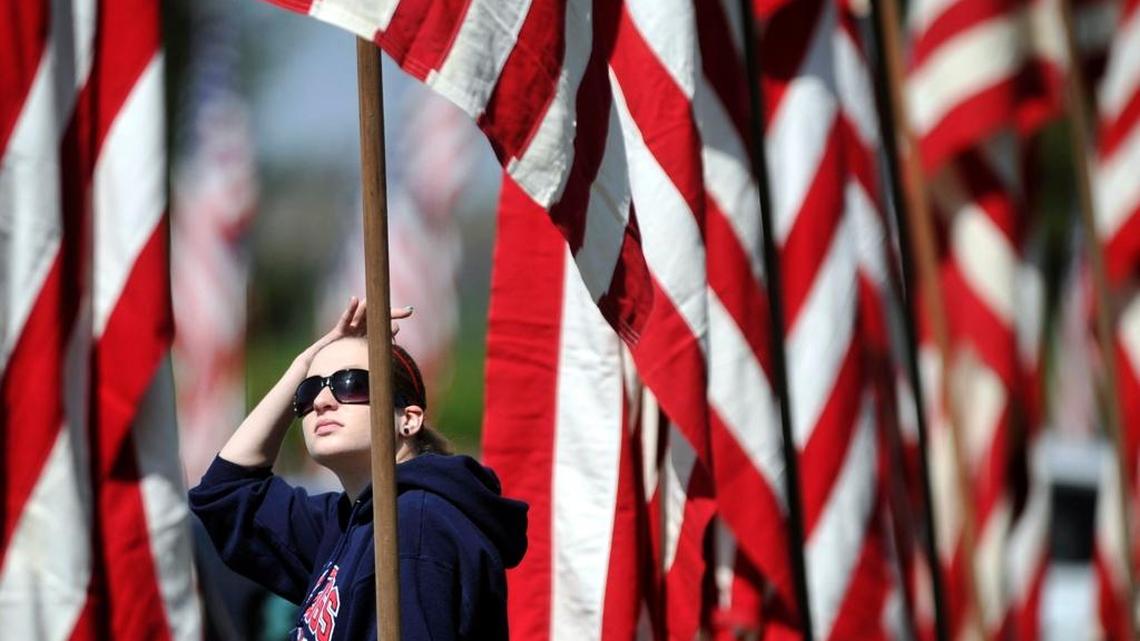 Katie Blankinship searches for her great-grandfather Bill Stiggins’ name on the Avenue of Flags before the start of the 2015 VFW Memorial Day Service at Fresno Memorial Gardens. Blankinship said her great-grandfather served in the Army and died in World War II.
