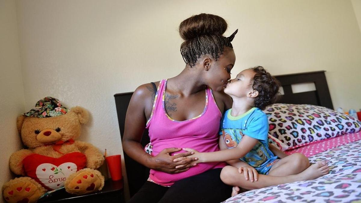 Karmerica Wiseman, kisses her son, Jairyden Wiseman, in Fresno in 2015. Wiseman, who at the time was 5 months pregnant with her second child, credited the Black Infant Health Program for a healthier pregnancy.
