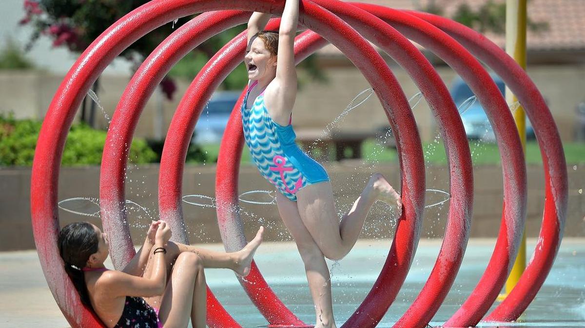 
Telena Garcia, 9, left, of Fresno, plays in the water park with her cousin Hailey Casarez, 9, also of Fresno, at Figarden Loop Park in northwest Fresno, California, on July 31, 2015. Temperatures topped 100 degrees although a cool down could start on Sunday.
