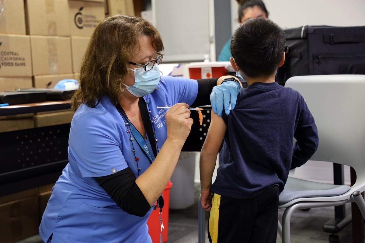 A nurse vaccinates a child during a Dec. 17 COVID-19 vaccination clinic in Fresno.