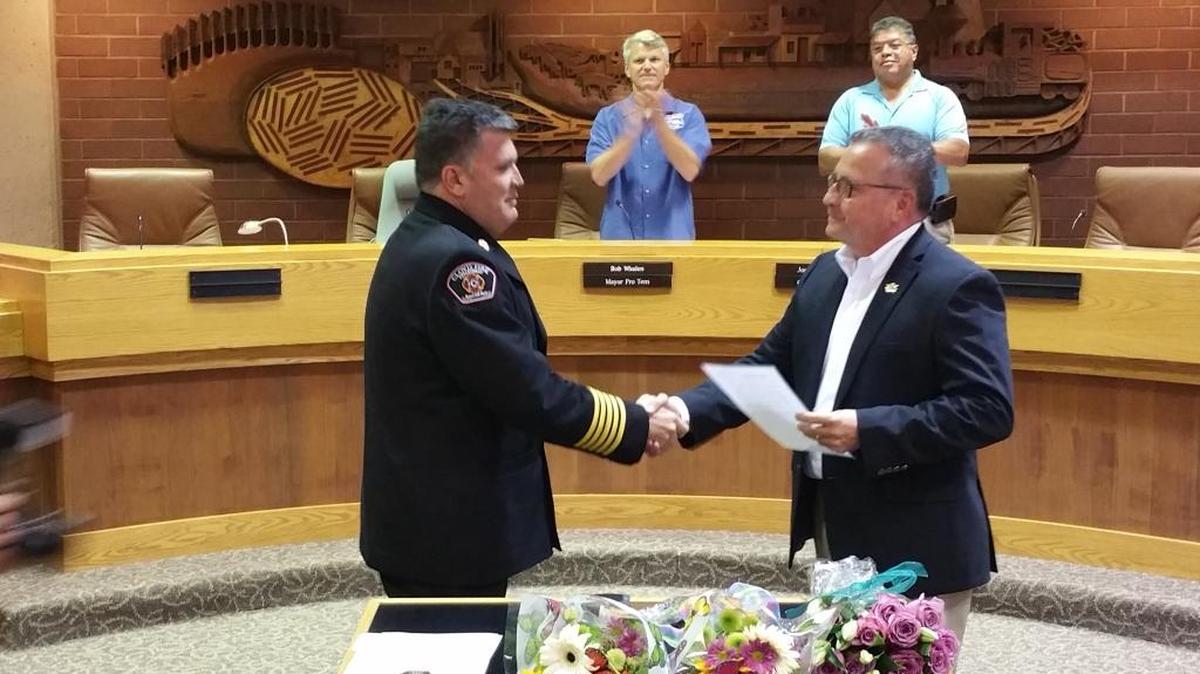 John Binaski (left) is sworn in as fire chief for the city of Clovis by City Clerk John Holt at the Clovis City Council meeting on Monday, July 18, 2016.