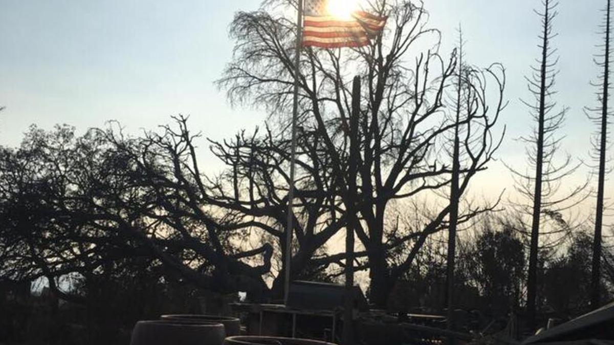 Merced firefighters found an American flag untouched by the fires ravaging Northern California and hoisted it back up over a pile of rubble.