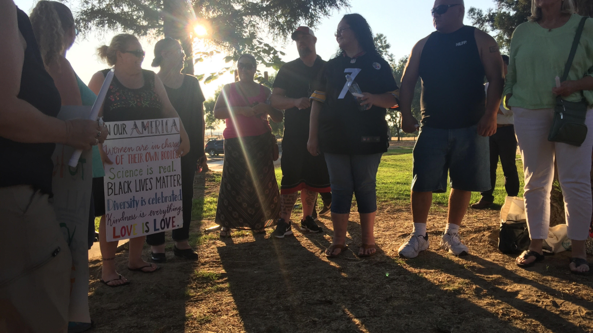 Community members stand in solidarity at a vigil on Aug. 12, 2017, at Fresno’s Woodward Park to take a stand against violence in Charlottesville, Virginia.
