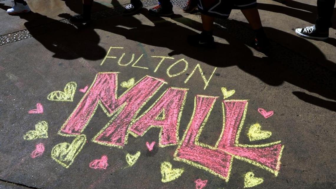 Visitors walk past chalk drawings created to support pedestrian traffic along the Fulton Mall during a rally on Feb. 22, 2014 in downtown Fresno. Bids to open the mall to vehicle traffic came in higher than expected on Tuesday.