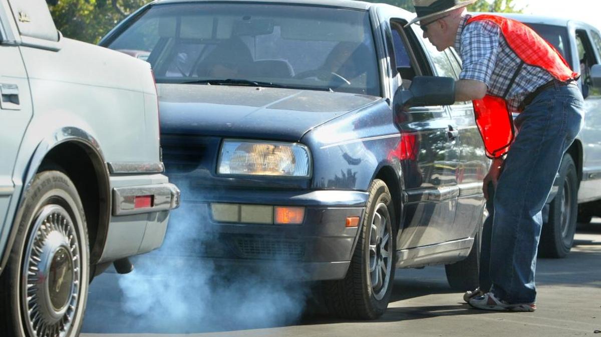 Doug Lawson talks with a motorist who is behind of a smoking vehicle as he helps out during a 2007 free smog check similar to one planned for this Saturday, Oct. 31, at the Fresno Fairgrounds.