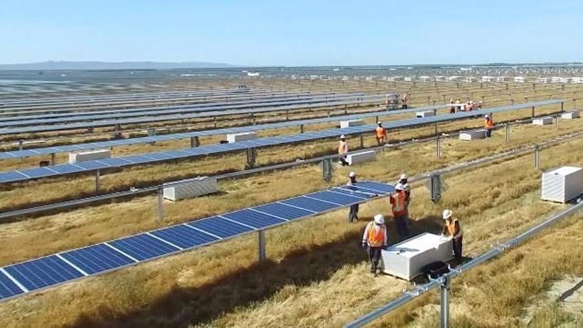 Construction crews install solar photovoltaic panels at the 1,900-acre Tranquillity Solar Facility in western Fresno County, in this frame from a Recurrent Energy video.
