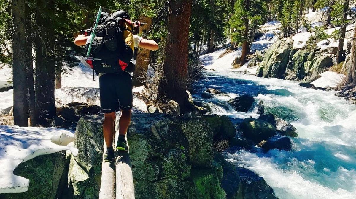In this Friday, June 16, 2017, photo, Jake Gustafson crosses Bear Creek along the Pacific Crest Trail near Kings Canyon National Park, Calif. With hundreds of so-called thru-hikers entering the high Sierra early in the season, their experiences serve as a cautionary tale for others planning weekend or summer wilderness escapes. More than a dozen people have drowned in Sierra rivers at lower elevations, including one in Yosemite and three in Sequoia National Park, and rangers are warning hikers to think twice about crossing swift water.