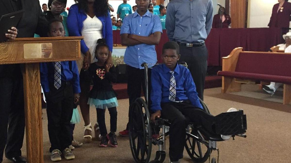 Deshaun Mitchell (center right) was honored with a plaque at Saint Rest Baptist Church in southwest Fresno Sunday after he shoved his brother away from an oncoming SUV while crossing a southwest Fresno intersection in January.