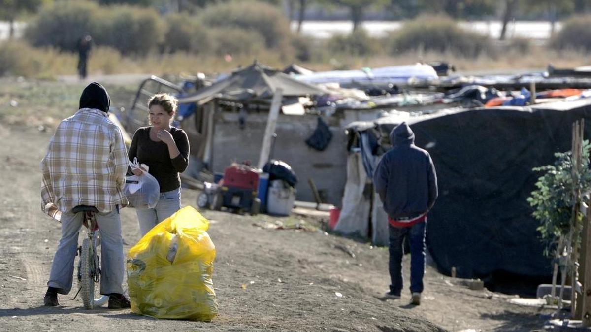 Lupe Baeza talks with another resident of the homeless camp in a dry ditch near Mendota, where Clinica Sierra Vista’s mobile clinic paid a visit last month.