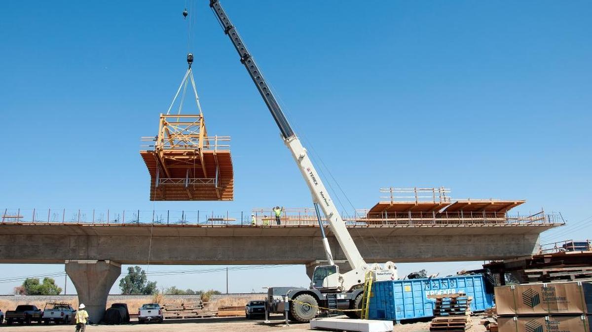 A crane lifts forms into place at the Fresno River Viaduct, which will carry high-speed train tracks over the Fresno River, Highway 145 and Raymond Road at the eastern edge of Madera.