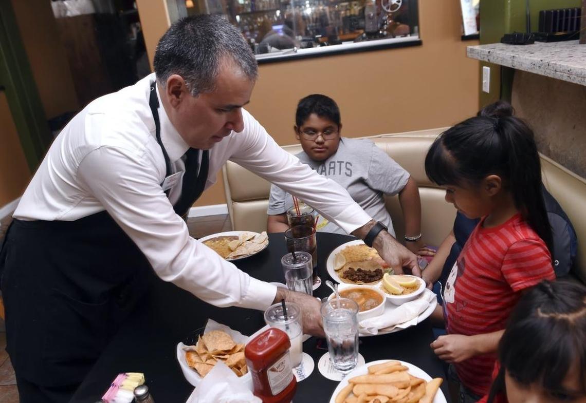 Gerardo Amezola, left, serves meals to Jesse Toledo’s children in this file photo from 2017.