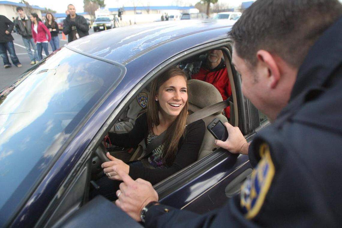 Clovis High School student Megan Buettner, 17, is briefed in 2018 by California Highway Patrol officer Matt Radke prior to driving a challenging course in which she will be texting while driving. She and three other students ran through the course in front of a crowd of fellow students during lunchtime to demonstrate the dangers of distracted driving.