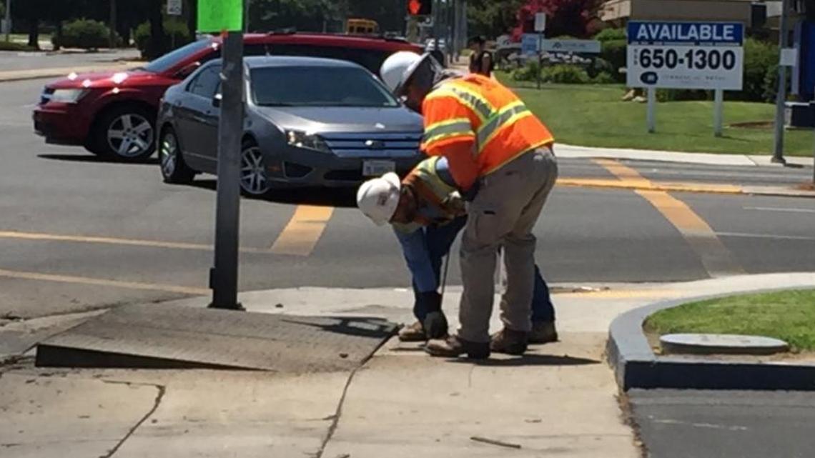 PG&E workers examine the electrical vault that blew up six inches out of the ground Friday causing a power outage in north Fresno.