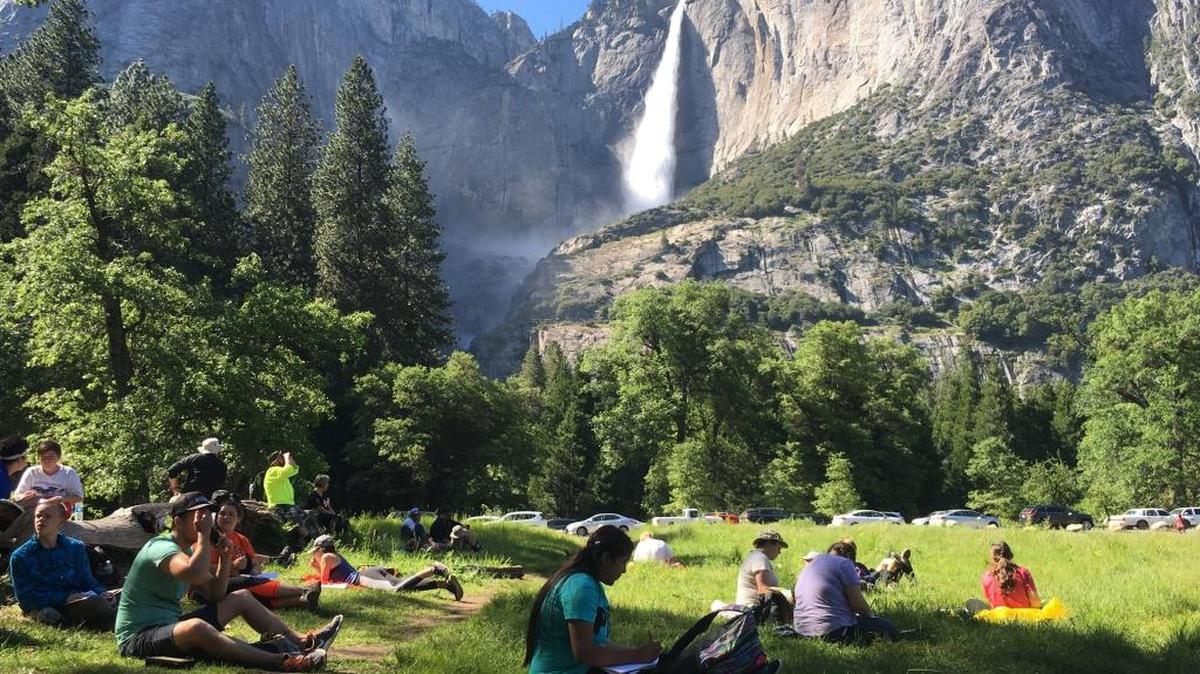 A class of eighth-graders and their chaperones sit in a meadow at Yosemite National Park below Yosemite Falls in May 2017. Getting to the park was a little more difficult Saturday, June 24, 2017, thanks to the latest rockslide on El Portal Road.