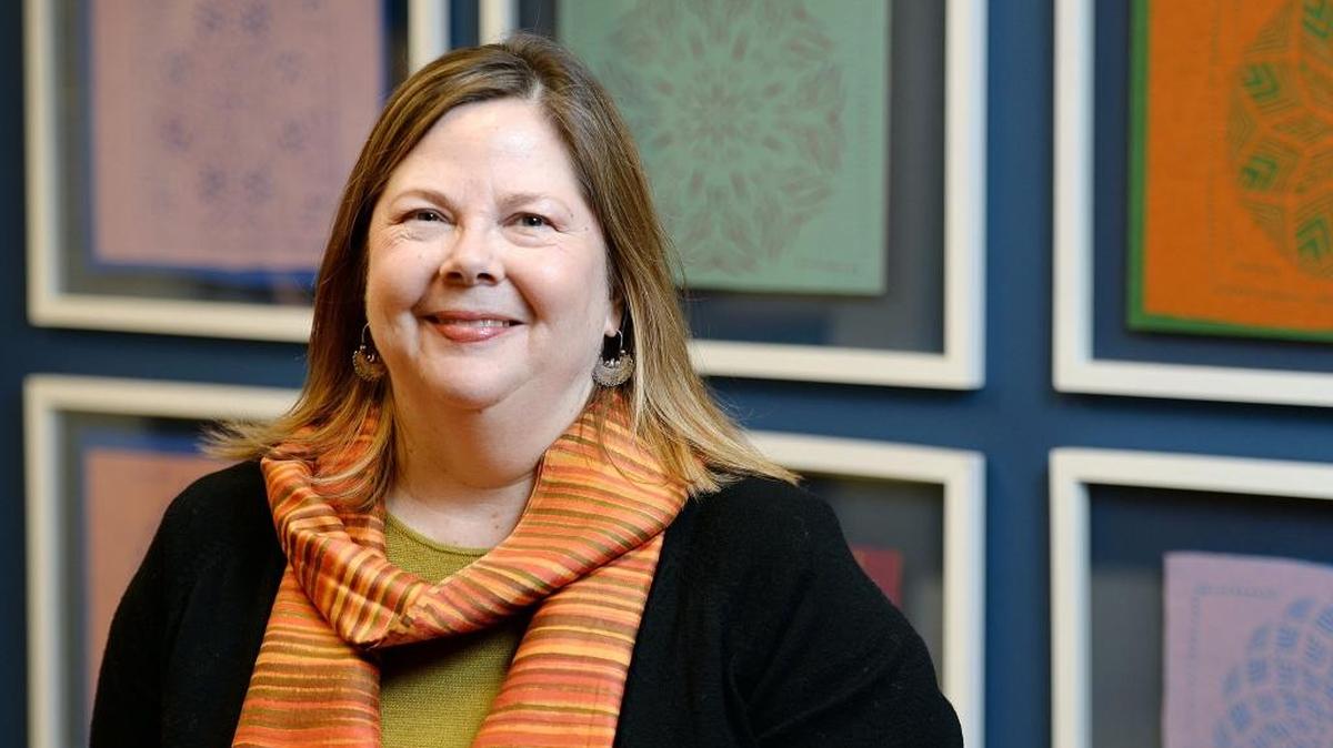 Amy Kitchener, executive director of the Alliance for California Traditional Arts, is photographed at her Fresno office in front of Papel Picado pieces or cut paper art by Herminia Albarran Romero, an NEA National Heritage fellow from San Francisco, on Wednesday. Kitchener has been named to board of the American Follklife Center at the Library of Congress.