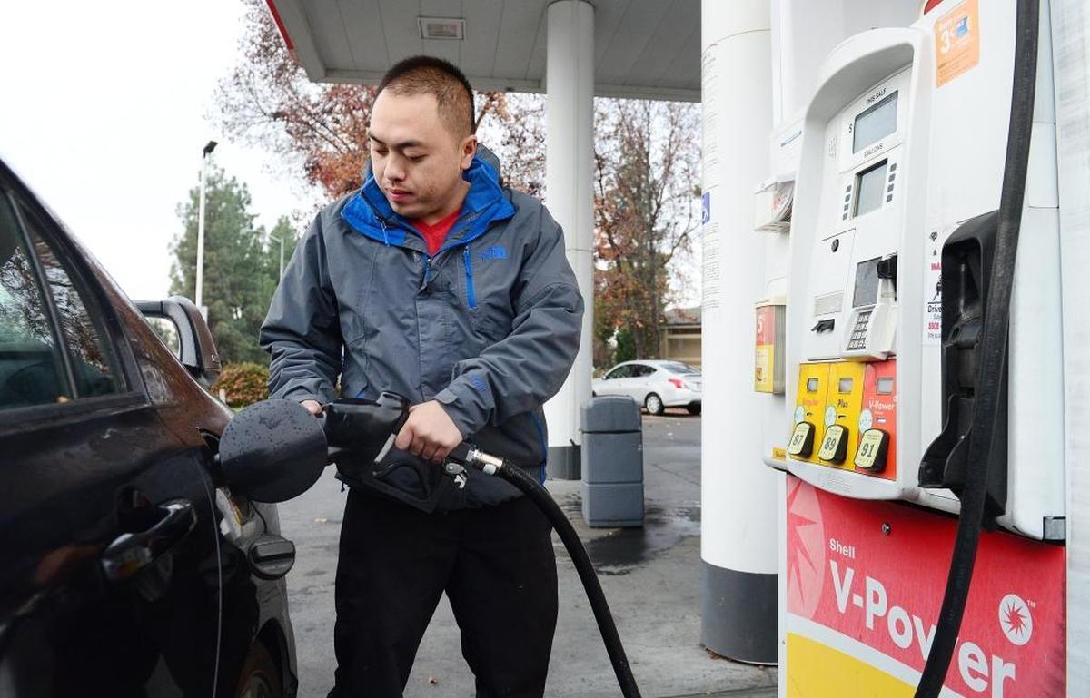 Kou Vue of Fresno pumps gas at a Shell gas station on McKinley and Peach avenues in Fresno, Friday, Dec. 23, 2016.